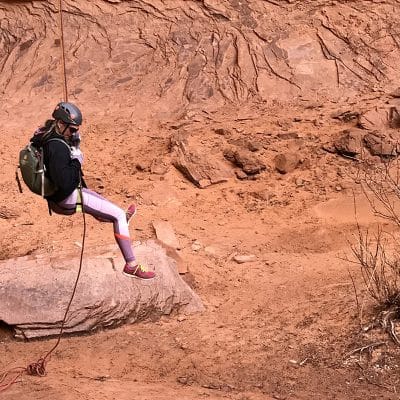 Miss Ali rappelling down a cliff